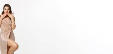 Noel partisi ve kutlama konsepti. Zarif bir gece elbisesi içinde uzun ve alımlı bir kadın. Şaşkın şaşkın bakıyor ve 