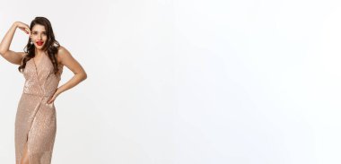 Parti ve kutlama konsepti. Noel hediyelerinin yanında poz veren, gece elbisesi giyen beyaz arka planda duran çekici bir kadın..