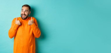 Neşeli adam övgüler yağdırıyor ve sol üst köşeye bakıyor, afallamış, süper havalı ürünler sergiliyor, açık mavi arka planda duruyor..