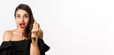 Nişan yüzüğüyle parmağını gösteren heyecanlı genç bir kadın nişanlandı ve beyaz arka planda dikilerek evet dedi..