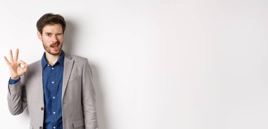 Her şey yolunda. Kendine güvenen erkek CEO 'su işaret veriyor ve göz kırpıyor. Her şey kontrol altında. İyi iş çıkarmışsın..