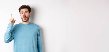 Heyecanlı yakışıklı bir adamın bir fikir sunduğu, parmağını kaldırdığı ve 