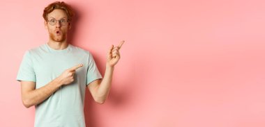 Kızıl sakallı ve saçlı, etkileyici beyaz adam, sağ üst köşeyi işaret ediyor ve hayrete düşüyor, 