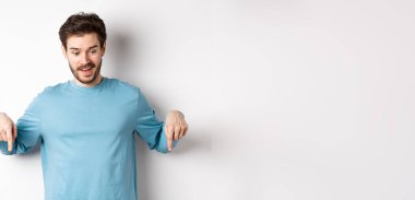 Yakışıklı beyaz adam, etkilenmiş ve mutlu yüzüyle, gülümsüyor ve 