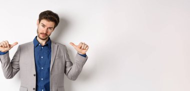 Kendine güvenen, profesyonel görünümlü, kendini gösteren, kendi reklamını yapan, beyaz arka planda duran kendine güvenen bir adam..