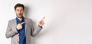 Heyecanlı, beyaz takım elbiseli beyaz iş adamı logoyu işaret ediyor, 