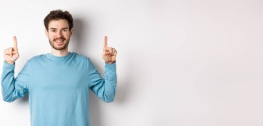 Fotokopi alanında reklam yapan, parmaklarını kaldırıp gülümseyen sakallı genç bir adamın resmi..