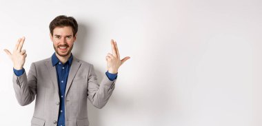 Heyecanlı ve başarılı bir iş adamı beyaz arka planda duran mutlu, motive olmuş ve pozitif hissediyor..