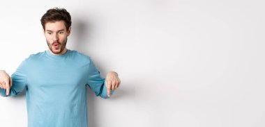 Yakışıklı adam, etkilenmiş ve mutlu yüzüyle, gülümsüyor ve 