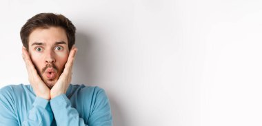 Etkilenmiş bir adamın özel teklifi kontrol edişinin yakın plan çekimi, hayret verici bir ifadeyle dokunuşunu, hayranlıkla kameraya bakışını, beyaz arka planda duruşunu..