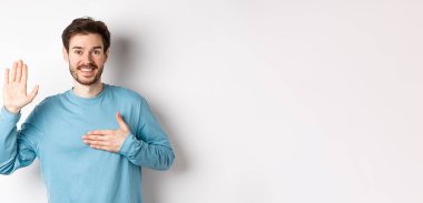 Gülümseyen hortlak adam kolunu kaldırır ve kalbe tutunur, söz verir doğruyu söyler, yemin eder ya da yemin eder, beyaz arka planda durur..