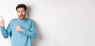 Harika bir tanıtım teklifi sunan, sol üst köşedeki logoyu işaret eden, heyecanlı görünen, ürün öneren, beyaz arka plan.