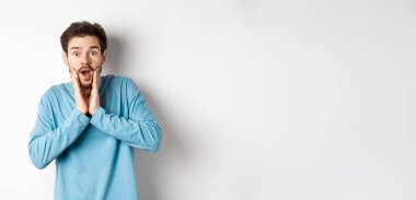 Yakışıklı adamın görüntüsü soluk soluğa kaldı ve kameraya baktı. Şaşırdı, müthiş tanıtım tekliflerine baktı, beyaz arka planda durdu..