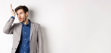 Adam çok aptal biriyle şok oldu. Kızgın işadamı gözlerini devirir ve çılgın müşteriler tarafından rahatsız edilir, takım elbise içinde beyaz arka planda dururlar..