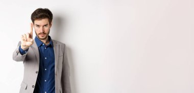 - Beni dinle. Ciddi bir erkek CEO 'nun tek parmağını göstermesi, azarlaması ya da durmasını söylemesi, hayır, tam orada dur işareti, takım elbise içinde beyaz arka planda duruyor..