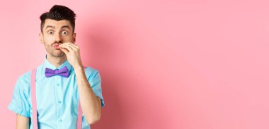 Bıyıklı ve papyonlu komik bir adam imajı şeflere öpücük hareketi gösteriyor, harika bir ürün, yemekleri övüyor, pembe arka planda duruyor..