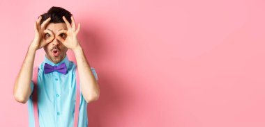 Reklamları kontrol ediyorum. Papyonlu etkileyici bir adam, el dürbününden bakıyor ve şöyle diyor: Vay canına, havalı reklamlara bakıyor, pembe arka planda duruyor..