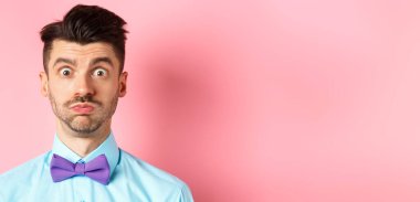 Kafası karışmış, nefes alan, somurtan, kameraya bakan, şaşkın, şen şakrak, papyon takan, pembe arka plan....