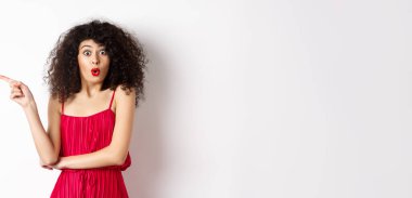 Şaşırmış, kırmızı elbiseli zarif bir kadın. 