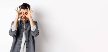 Komik adam el dürbününden bakıyor, muhteşem tanıtımlara bakıyor, 