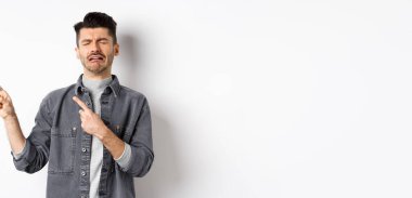 Üzgün ağlayan adam sol logoyu işaret ediyor, hıçkıra hıçkıra ağlıyor, ağlıyor ya da üzülüyor, beyaz arka planda duruyor..