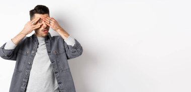 Çok ilginç. Meraklı bir adam kameraya bakıyor, şaşkın şaşkın bakıyor, beyaz arka planda duruyor..