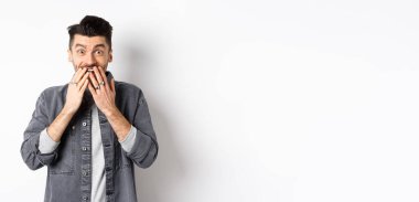 Mutluluktan gülen mutlu adam, şaşkınlık ve inançsızlıkla bak, hediyeyi al, beyaz arka planda dur..