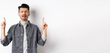 Üzgün ve sefil bir adam ağlarken parmaklarını havaya kaldırıyor, hayal kırıklığına uğramış reklamlar yapıyor, hıçkıra hıçkıra ağlıyor, beyaz arka planda duruyor..