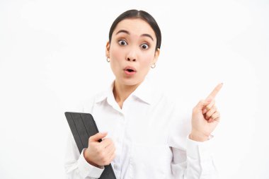 Genç, profesyonel bir kadın resmi, sağ eli işaret eden, dijital tablet tutan, reklam kampanyasını gösteren, beyaz arka planda izole edilmiş.