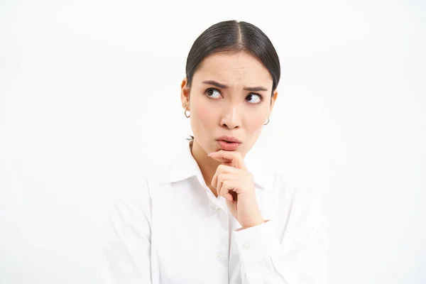 Stock image Portrait of businesswoman, asian lady boss thinks, looks thoughtful, pondering something with serious face, standing over white background.