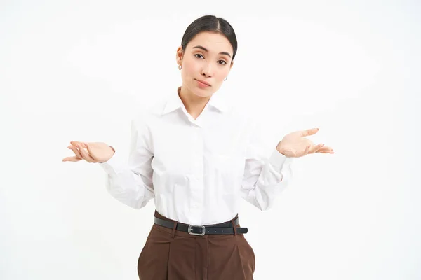 stock image Portrait of asian woman shrugs shoulders, looks confused and clueless, stands over white studio background.