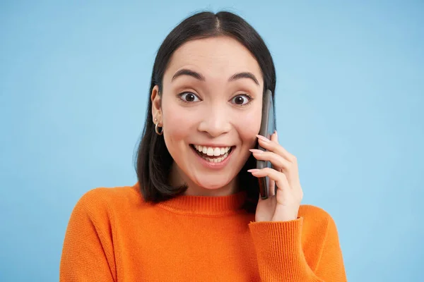 Veselá Asiatka Mluví Mobilu Mluví Někým Telefonu Stojí Nad Modrým — Stock fotografie