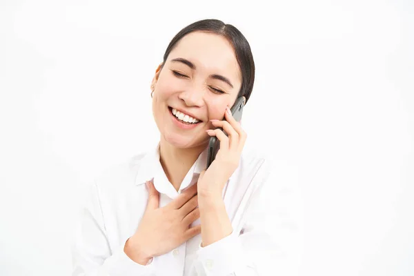 Portrait of asian corporate woman, businesswoman talks on mobile phone, has conversation over cellphone, speaking on telephone, white background.