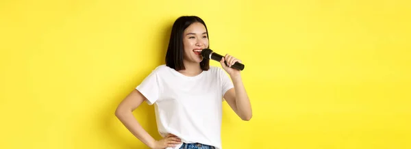 Mujer Asiática Feliz Cantando Canción Karaoke Sosteniendo Micrófono Mirando Lado —  Fotos de Stock