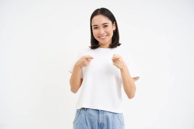 25 yaşında, sevimli, gülümseyen Koreli bir kızın portresi, kamerayı gösteriyor, sizi davet ediyor, tebrik ediyor, beyaz arka planda duruyor..