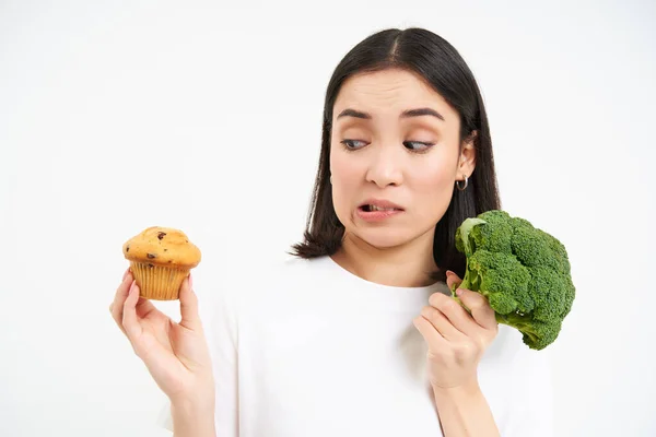 Image Vegeterian Girl Avoids Pastry Sticks Broccoli Eating Vegetables Instead Royalty Free Stock Images
