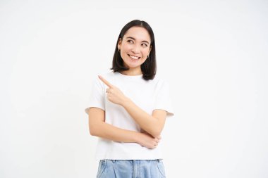 Güzel gülümseyen Asyalı kadın portresi, solu işaret eden, reklam gösteren, tavsiye edilen web sitesi, beyaz arka planda izole edilmiş.