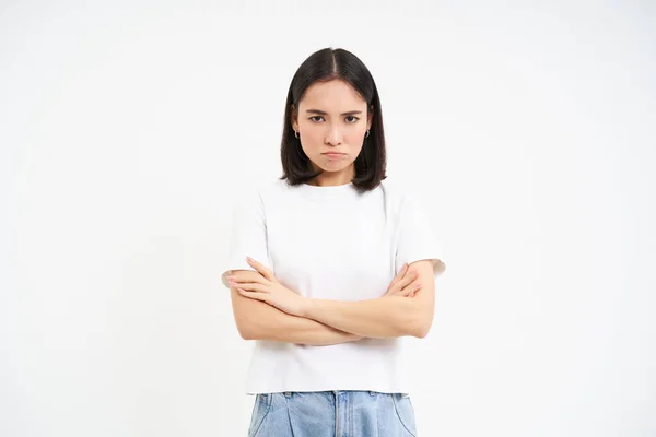 stock image Angry korean girl, looks upset and offended, pouts and frowns, stands against white background. Copy space