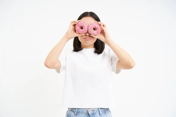 Изображение Смешной Молодой Женщины Делает Очки Двумя Розовыми Глазурованными Пончиками — стоковое фото