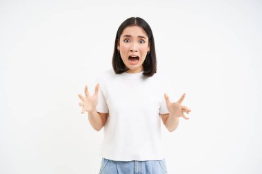 Korkmuş Asyalı kadın görüntüsü, endişeli ve endişeli görünüyor, dehşete kapılmış bağırıyor, beyaz arka planda duruyor..