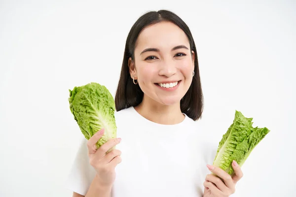 快乐的韩国女性素食主义者 笑着展示卷心菜 吃生菜 过着积极的生活 背景洁白 — 图库照片