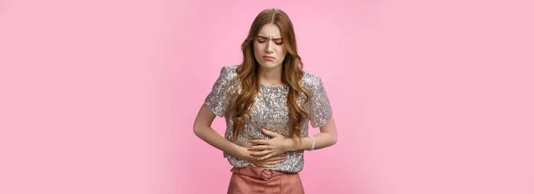 肖像画のパーティーの女の子は痛みを曲げ痛みを停止痛い腹痛を感じ 腹の苦しみ月経けいれんを触れ 悪いファーストフードを食べたい嘔吐 立って不快感ピンクの背景 — ストック写真