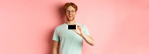 Joven Feliz Con Pelo Rojo Mostrando Pantalla Del Teléfono Inteligente —  Fotos de Stock
