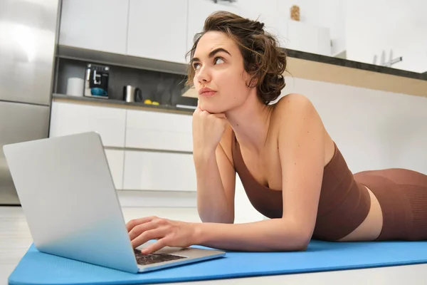 Fitness Girl Lying Rubber Mat Thoughtful Face Using Laptop Fitness — Stock Photo, Image