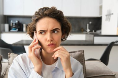 Cep telefonuyla konuşan, sorunlu yüzlü, karmaşık konuşmaları dinleyen, birini ararken düşünen bir kadının portresini kapat..