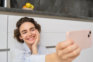Mutlu, güzel bir kadının portresi akıllı telefondan selfie çeker, elini cep telefonuyla uzatır ve kendi fotoğrafını çeker, cep telefonuyla video kaydını kaydeder..