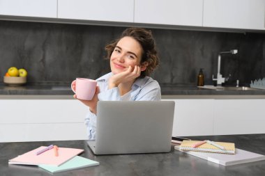 25 yaşındaki bir kadının portresi, internetten öğrenim görüyor, internetten ders alıyor, bilgisayarında çalışıyor..