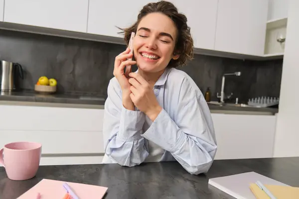 stock image Portrait of cute smiling girl talks on mobile phone, sits at home and calls someone with smartphone.