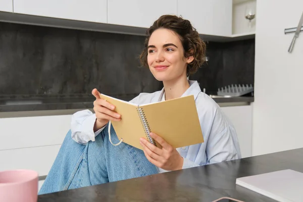 stock image Portrait of businesswoman at home, wrtiting in journal, making plans in her planner, spending time indoors.