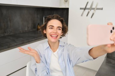 Genç kadın portresi, blogcu cep telefonuyla selfie çekiyor, akıllı telefon uygulaması ile video kaydediyor..